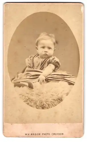 Fotografie W. H. Mason, Croydon, 89, George Street, Kleines Mädchen im Kleid sitzend auf einem Fell