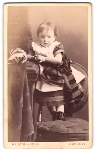 Fotografie Ralston & Sons, Glasgow, 141, Sauchiehall Street, Kleines Mädchen im elegante Kleid stehend auf einem Stuhl