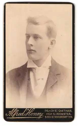 Fotografie Alfred Honey, Chatham, 114 High Street, Portrait Bursche im Anzug mit weisser Krawatte