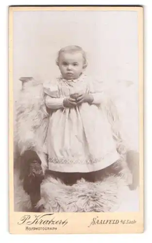 Fotografie P. Kratzert, Saalfeld a. d. Saale, Portrait kleines Mädchen im weissen Kleid mit Ball in der Hand