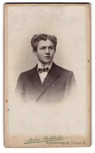 Fotografie Belitski, Nordhausen, Freiheit 14, Portrait junger Mann im Anzug mit Fliege und Locken