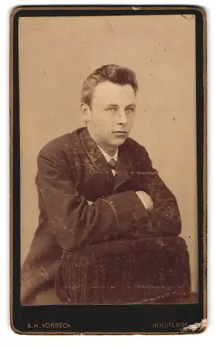 Fotografie A.H. Vorbeck, Holstebro, Portrait Bursche an Sessel lehnend