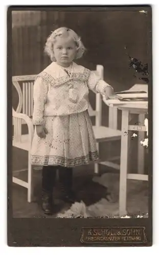 Fotografie K. Scholl & Sohn, Friedrichshafen-Tettnang, Kleines Mädchenim weissen Kleid mit blonden Haaren