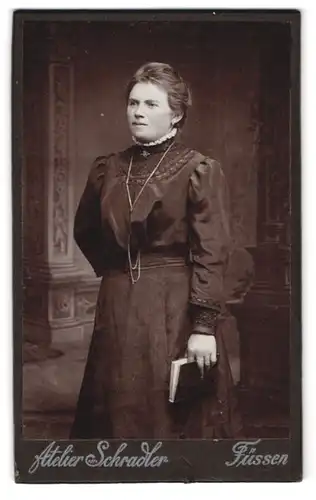 Fotografie Atelier Schrader, Füssen, Hübsche Frau im dunklen Kleid mit Buch