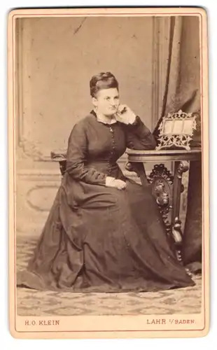 Fotografie H. O. Klein, Lahr / Baden, Kaiserstr., Frau im dunklen Kleid in einer nachdenklichen Pose