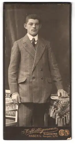Fotografie H. Billigmann, Hagen / W., Kampfstr. 12/14, Junger Mann im Anzug mit einem Buch