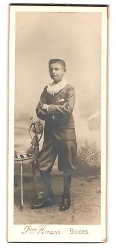 Fotografie Jeanne Hermans, Bruges, Place Maleberg, Knabe in eleganter Kleidung in Studiokulisse