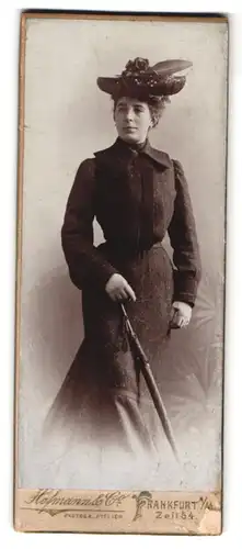 Fotografie Hofmann & Co., Frankfurt a. M., Zeil 54, Portrait Dame im gemusterten Kleid mit Hut und Schirm