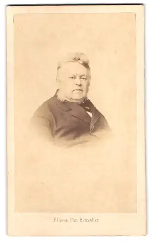 Fotografie F. Deron, Bruxelles, Rue de la Madeleine 13, Portrait dicker Mann im Anzug mit Backenbart