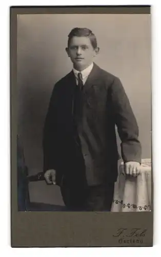 Fotografie F. Fels, Herisau, Portrait junger Mann im Anzug mit Schlips und Segelohren