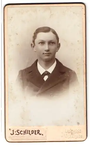 Fotografie J. Schilder, Lausanne, rue de Bourg, Portrait junger Knabe im Anzug mit Segelohren