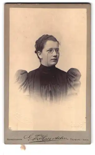 Fotografie G. Th.Hase & Sohn, Freiburg i. Baden, Portrait Dame im Kleid mit Zwicker Brille und Puffärmeln