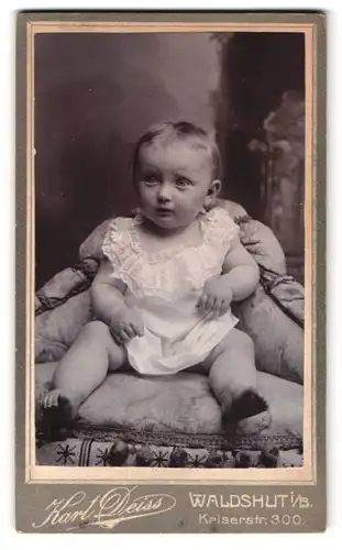 Fotografie Karl Deiss, Waldshut i. B., Kaiserstr. 300, Portrait Kleinkind im weissen Kleid sitzt im Atelier