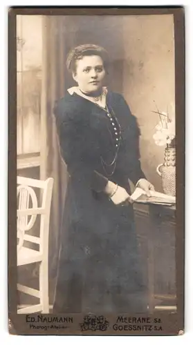 Fotografie Ed. Naumann, Meerane i. Sa., Augustusstr. 33, Portrait bildschöne junge Frau am Tisch stehend