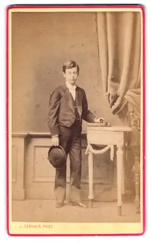 Fotografie J. Servais, Liege, Portrait charmanter Bube mit Hut in der Hand