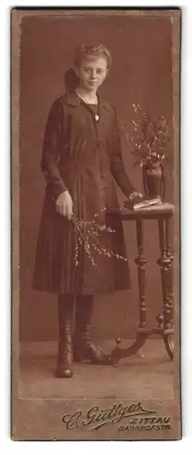 Fotografie C. Güttgers, Zittau i. Sa., Bahnhofstr., Portrait bildschönes Fräulein mit Blumen am Tisch stehend
