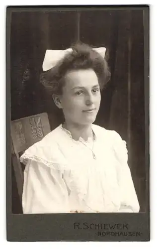 Fotografie R. Schiewek, Nordhausen, Töpferstrasse 1, junge lächelnde Dame mit Haarschleife und weissem Kleid