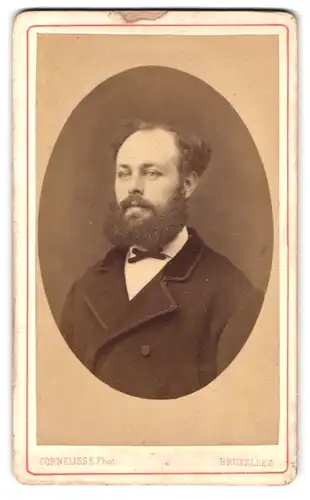 Fotografie Cornelisse, Bruxelles, Rue Neuve 22, Herr im Mantel mit Vollbart