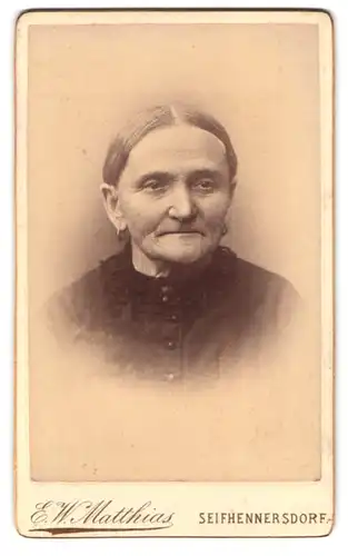Fotografie E. W. Matthias, Seifhennersdorf, Portrait ältere Dame im Kleid mit Ohrringen