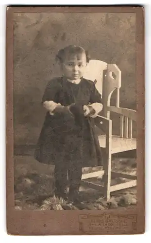 Fotografie Julius Grusche, Neugersdorf i. S., Portrait kleines Mädchen im schwarzen Kleid mit Haarschleifen