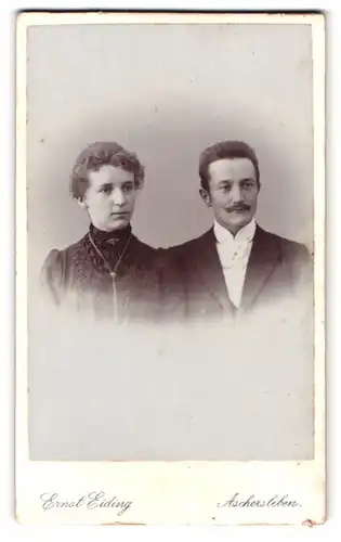 Fotografie Ernst Eiding, Aschersleben, Portrait Mann und Frau im Anzug mit weisser Fliege und Kleid mit Halskette
