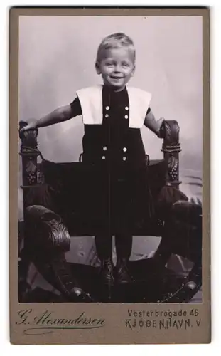 Fotografie G. Alexandersen, Kjobenhavn, Vesterbrogade 46, Fröhliches Kind auf Stuhl stehend