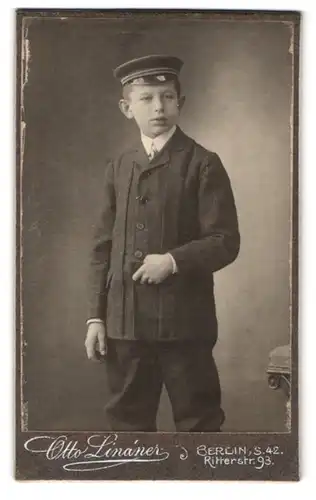 Fotografie Otto Lindner, Berlin, Ritterstr. 93, Portrait junger Knabe im Anzug mit Schirmmütze und Segelohren