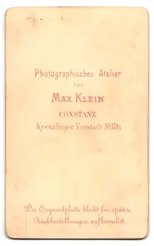 Fotografie Max Klein, Constanz, Kreuzlinger Vorstadt 370a, Portrait Kleinkind im Kleid sitzt auf einem Stuhl