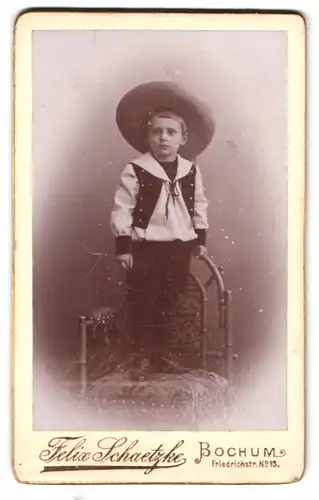 Fotografie Felix Schlaetzke, Bochum, Friedrichstr. 13, Portrait kleiner Junge im Anzug mit Sommerhut steht auf Stuhl