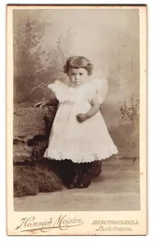 Fotografie Heinrich Meister, Bischofszell, Poststrasse, Niedliches Mädchen mit lockigem Haar in weissem Rüschenkleid