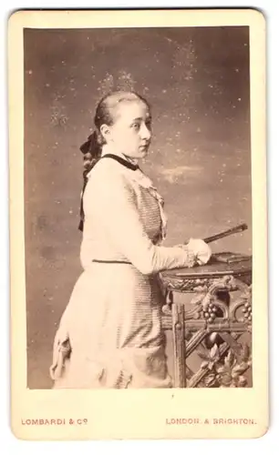 Fotografie Lombardi & Co., London, 13 Pall Mall East, Mädchen mit Zopf & Fächer im Sonntagskleid