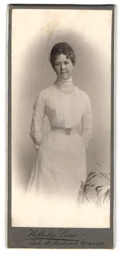 Fotografie Wilhelm Gau, Stralsund, Portrait junge Frau im weissen Kleid mit Gürtelschnalle und Locken