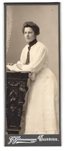 Fotografie G. Gronemann, Walsrode, Portrait junge Frau im weissen Kleid mit Schlips, blättert im Buch