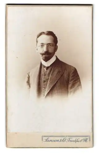 Fotografie Samson & Co., Frankfurt a. M., Zeil 46, Portrait Herr im karierten Anzug mit Brille und Heriquatre Bart