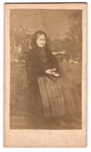 Fotografie Fotograf und Ort unbekannt, ältere Dame mit Haube und Büchern in der Hand