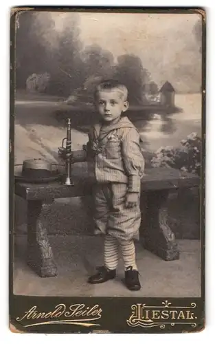Fotografie Arnold Seiler, Liestal, kleiner Junge im Anzug mit Trompete in der Hand