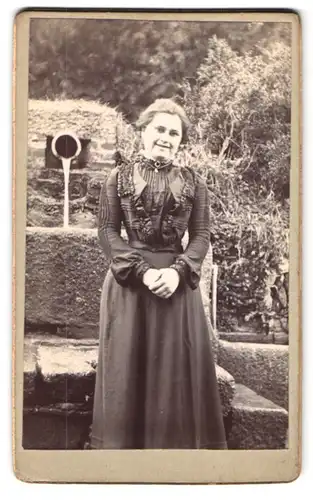 Fotografie Fotograf und Ort unbekannt, Portrait junge Frau im Biedermeierkleid posiert im Garten