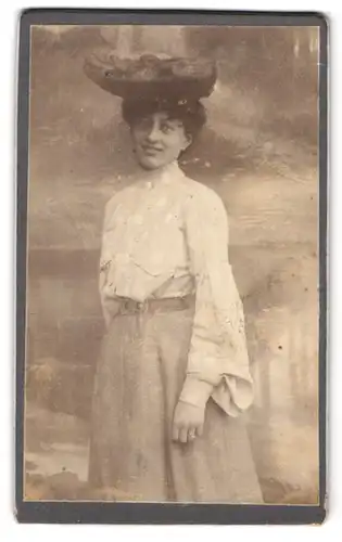 Fotografie Fotograf und Ort unbekannt, Portrait Dame in weisser Bluse mit breitem Hut vor einer Studiokulisse