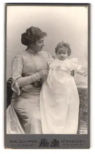 Fotografie Karl Schipper, Wiesbaden, Rheinstr. 31, Portrait Mutter im hellen Kleid mit kleiner Tochter im Arm, Locken