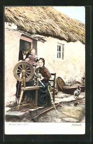 AK Irland, At the cabin door, Frau sitzt am Spinnrad