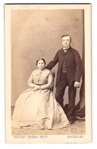 Fotografie Geruzet Freres, Bruxelles, 27 Rue de l'Ecuyer, Dame im Biedermeierkleid sitzend nebst Gatte