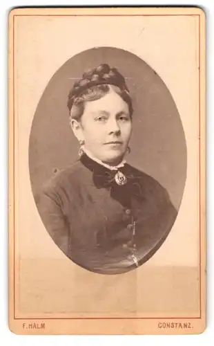Fotografie F. Halm, Constanz, Augustiner-Str. 590, Portrait Frau im Biedermeierkleid mit Brosche und geflochtenen Haaren