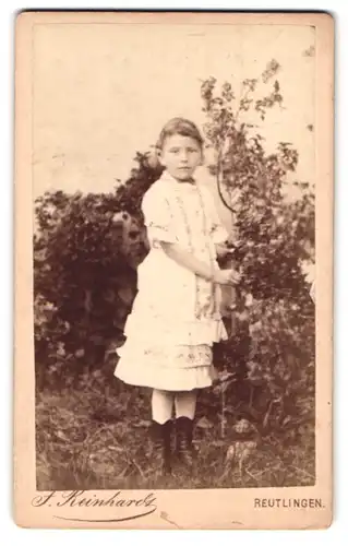 Fotografie J. Reinhardt, Reutlingen, Kleingraberstr. 330, Portrait Mädchen im weissen Kleid steht im Garten