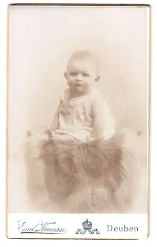 Fotografie Emil Krausse, Deuben, Dresdner Str., Portrait Kleinkind im weissen Kleid sitzt auf einem Fell