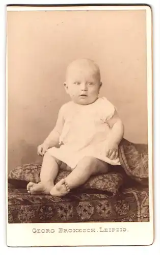 Fotografie Georg Brokesch, Leipzig, Zeitzerstr. 2, Portrait Baby im Leibchen auf einem Kissen sitzend