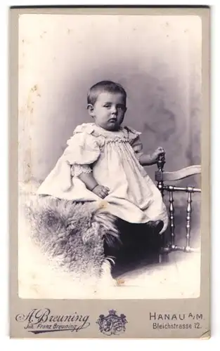 Fotografie A. Breuning, Hanau a. M., Bleichstr. 12, Portrait Kind im weissen Kleid schaut verschalfen