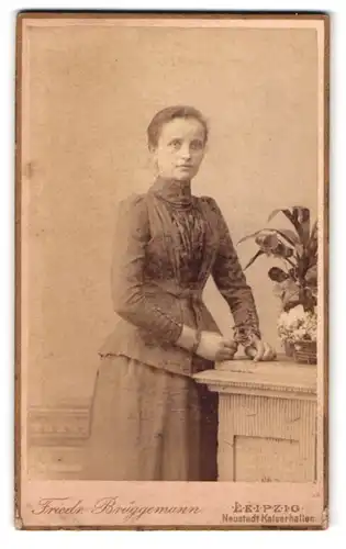 Fotografie Friedr. Brüggemann, Leipzig, Eisenbahnstr. 1, Portrait junge Frau im Biedermeierkleid mit Rose in der Hand