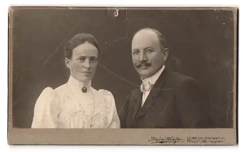 Fotografie Atelier Woelfer, Lübeck, Breitestr. 41, Portrait Mann und Frau im Anzug und weisser Bluse mit Anhänger