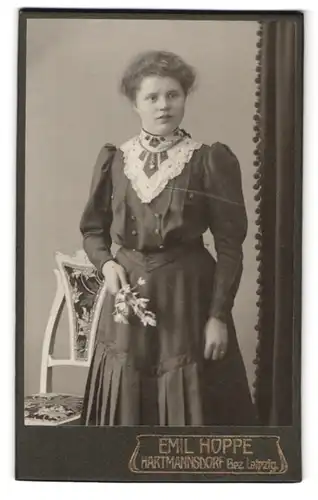 Fotografie Emil Hoppe, Hartmannsdorf, Portrait junge Dame im Kleid mit Spitzenkragen und Blumen in der Hand