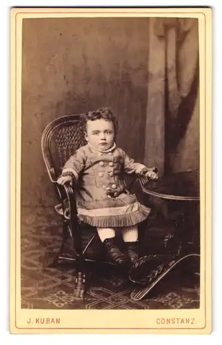 Fotografie J. Kuban, Constanz, Husenstr. 30, Portrait süsses kleines Mädchen mit Stiefelchen und Kleid